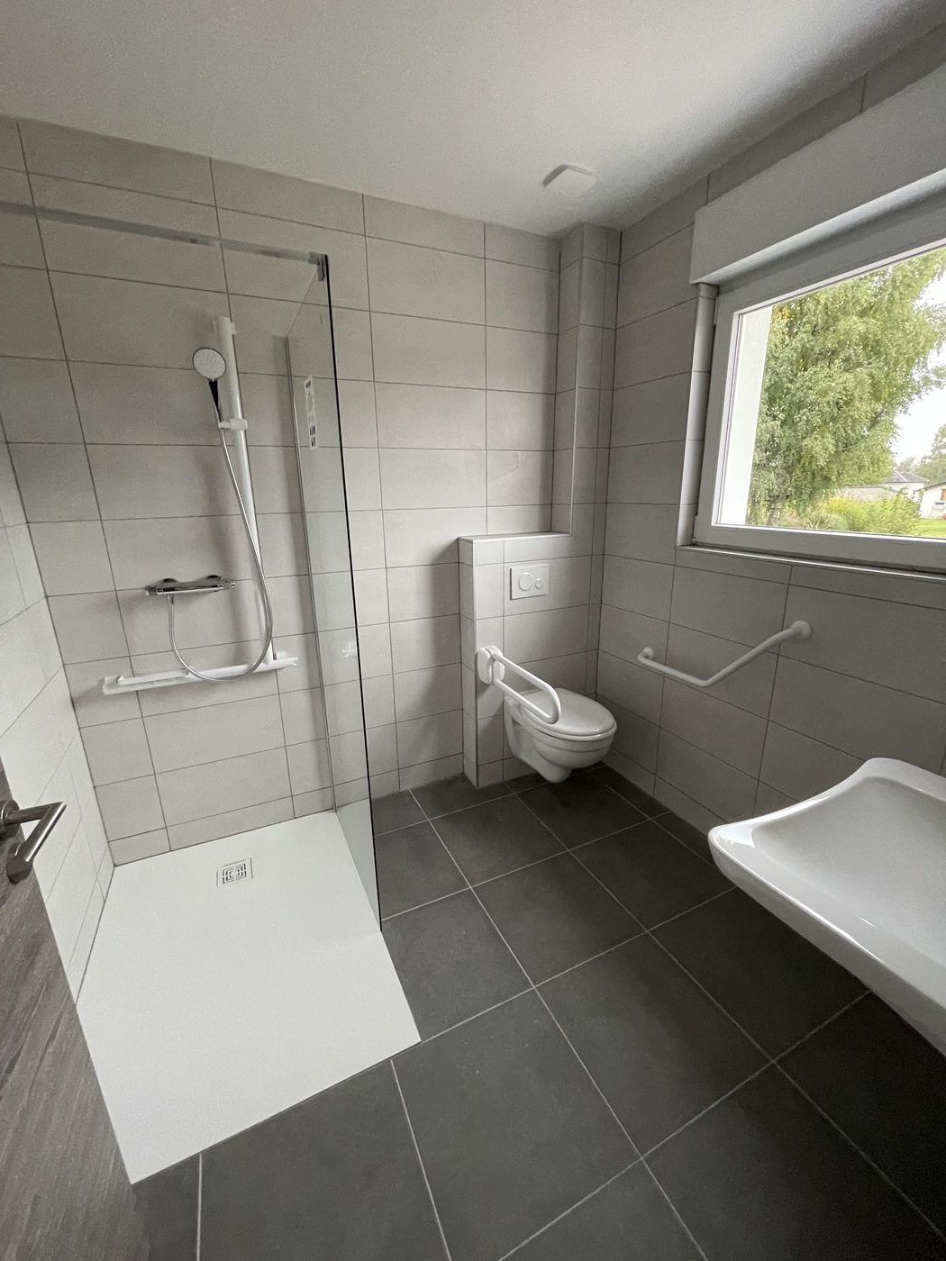 Salle de bain carrelage gris avec équipements sanitaires